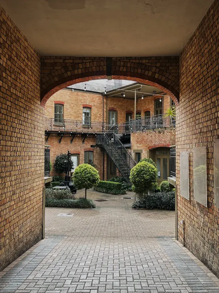 View through a brick arch into a courtyard garden